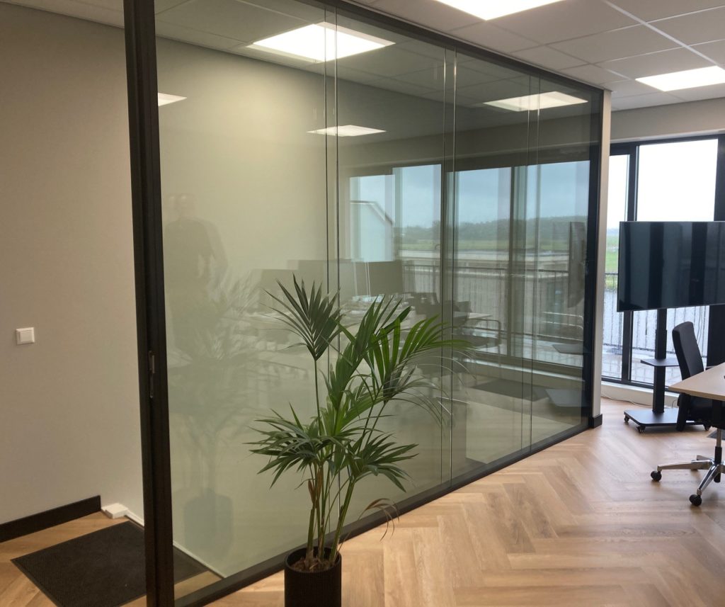 Het nieuwe pand van Financieringsgilde Groene Hart met de plafondhoge glazen afscheiding tussen trap en werkplek en mooie visgraatvloer. 